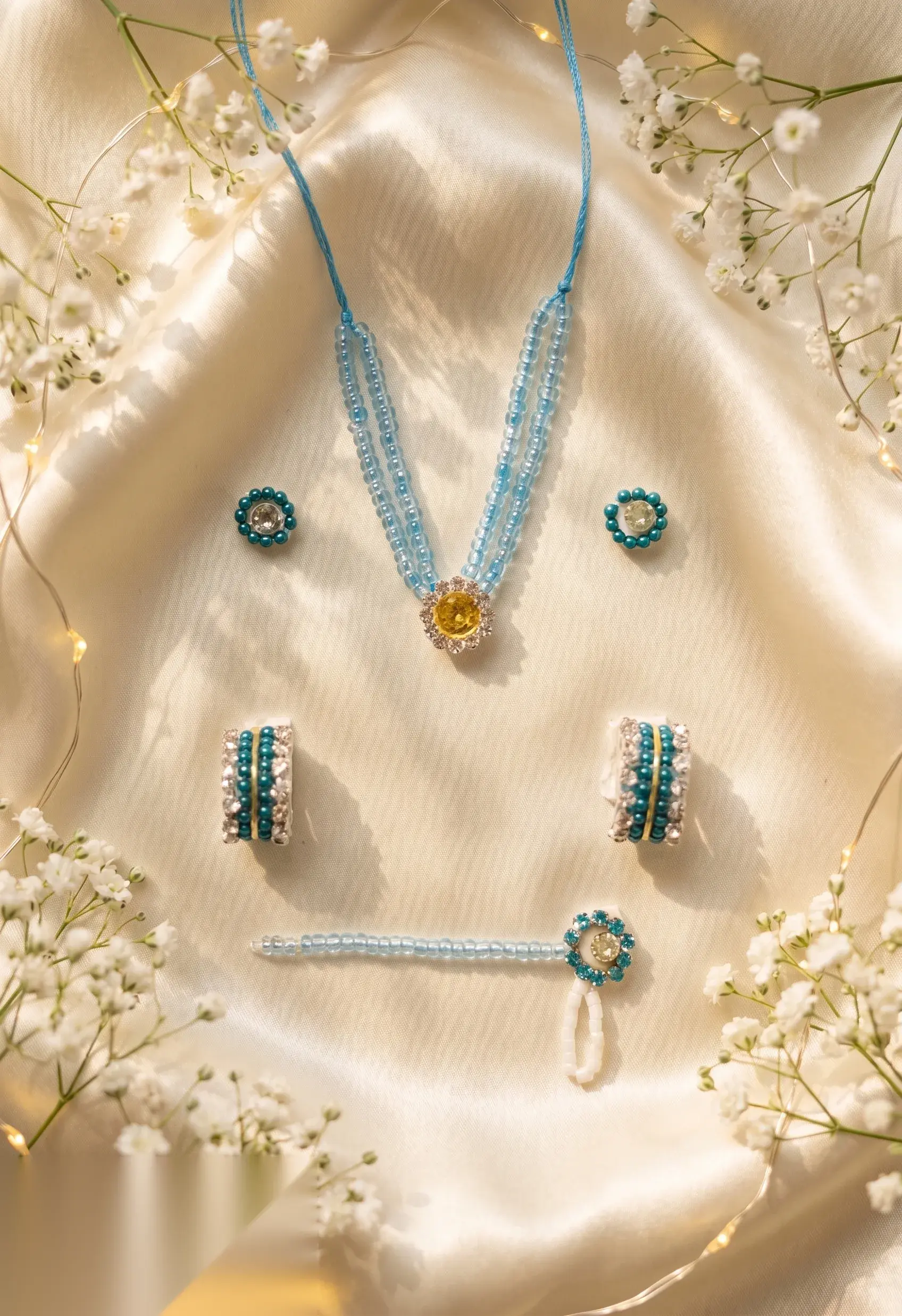 Close-up of hand-strung turquoise beaded necklace showing golden centre stone and matching earrings.