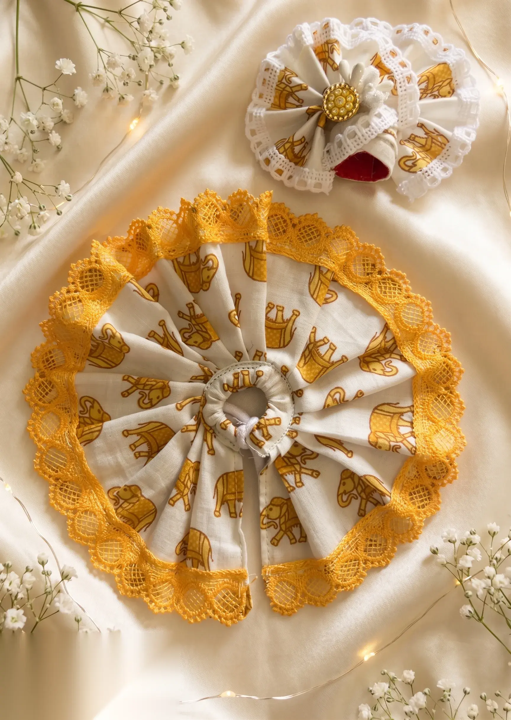 Mustard-yellow vastram with printed elephant motif and golden scalloped lace, paired with a matching pleated mukut.